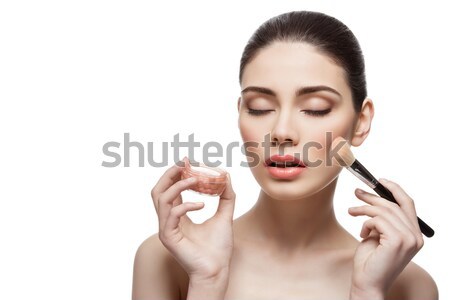 Beautiful girl applying blush with brush Stock photo © svetography