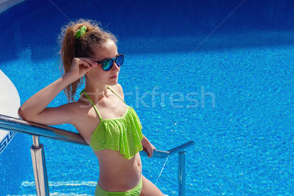 Stock photo: teen girl relaxing near swimming pool