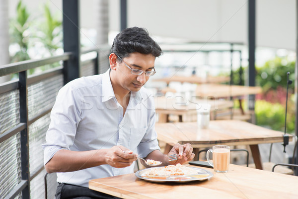 Indian businessman eating food Stock photo © szefei