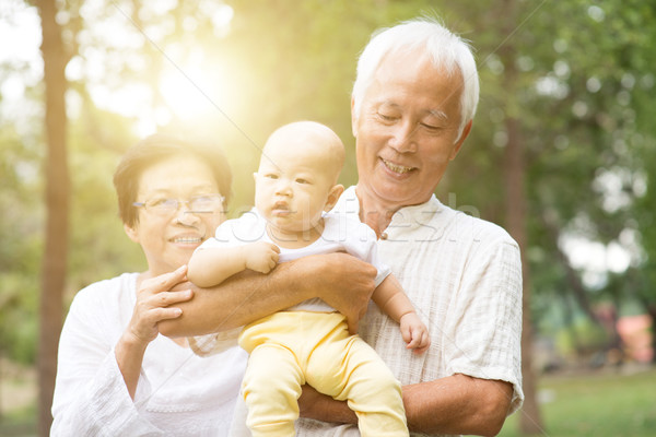 Stock photo: Grandfather, grandmother and grandchild outdoors.