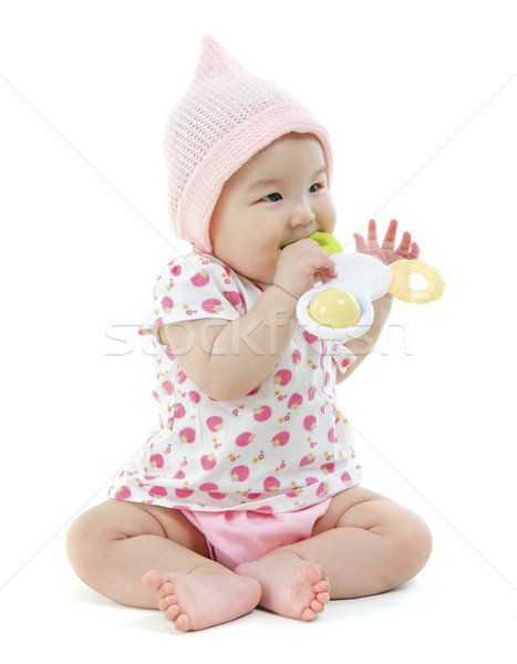 Asian baby girl biting on teething toy Stock photo © szefei