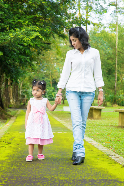 Indian mother and daughter walking outdoor. Stock photo © szefei