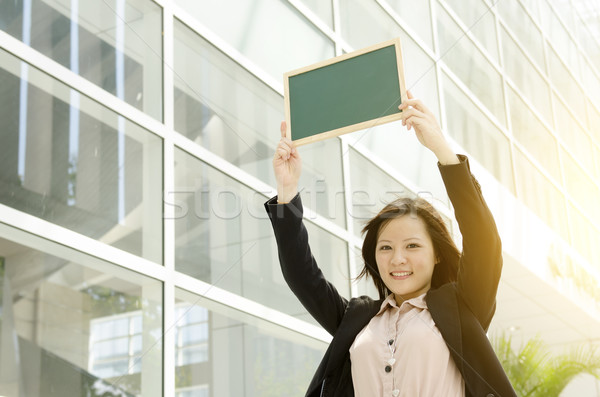Young Asian business woman showing blank chalkboard Stock photo © szefei
