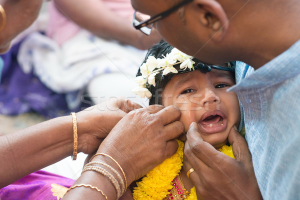 Baby girl crying in Hindus ear piercing ceremony Stock photo © szefei