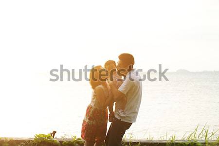 [[stock_photo]]: Parents · baiser · Kid · plage · coucher · du · soleil · famille · heureuse