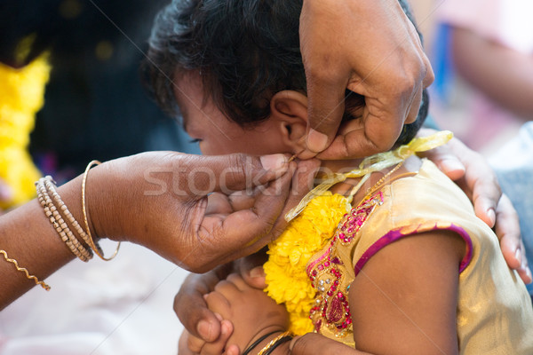 Baby girl in ear piercing ceremony Stock photo © szefei