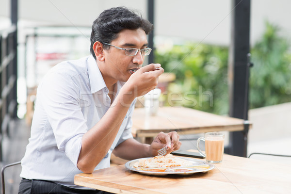 Indian business man eating food Stock photo © szefei