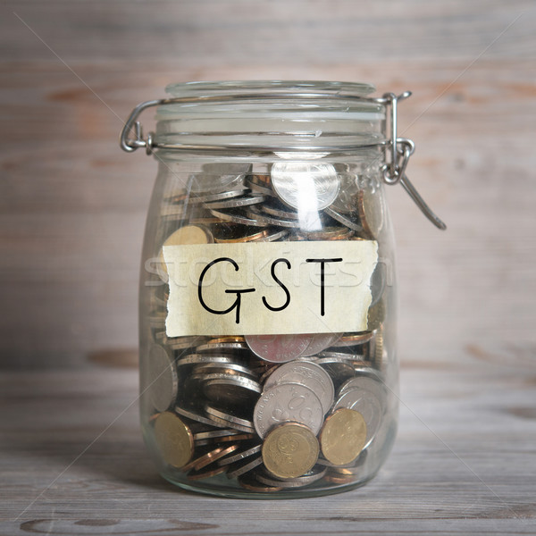 Coins in money jar with gst labe Stock photo © szefei