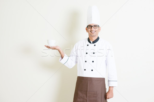 Indian male chef in uniform presenting a coffee cup Stock photo © szefei