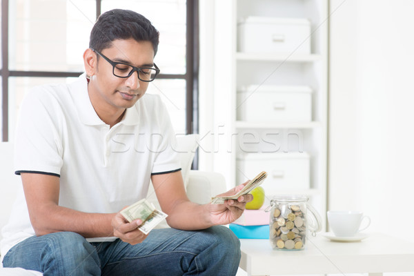 Sad Indian guy counting money Stock photo © szefei