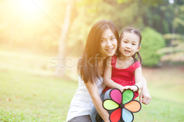 Asiatic mamă fiica joc moară de vânt în aer liber Imagine de stoc © szefei