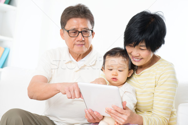 Asian family using tablet pc Stock photo © szefei