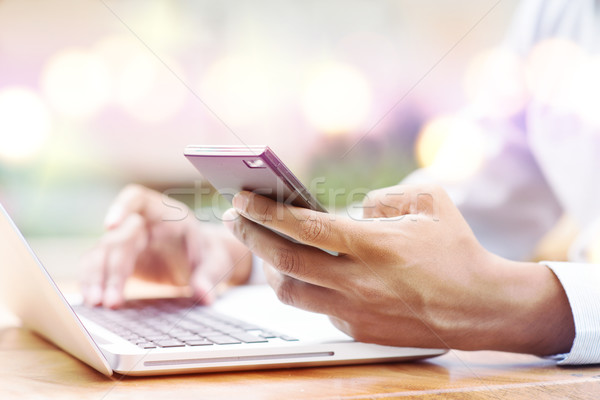 Man using smartphone and computer  Stock photo © szefei