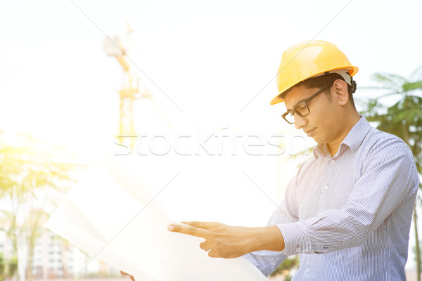 Asian Indian male contractor engineer reading blueprint Stock photo © szefei