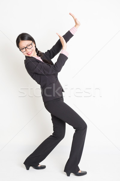 Asian businesswoman defending something Stock photo © szefei