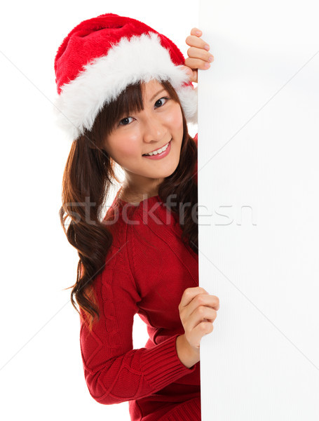 Christmas girl peeking from behind blank sign billboard.  Stock photo © szefei