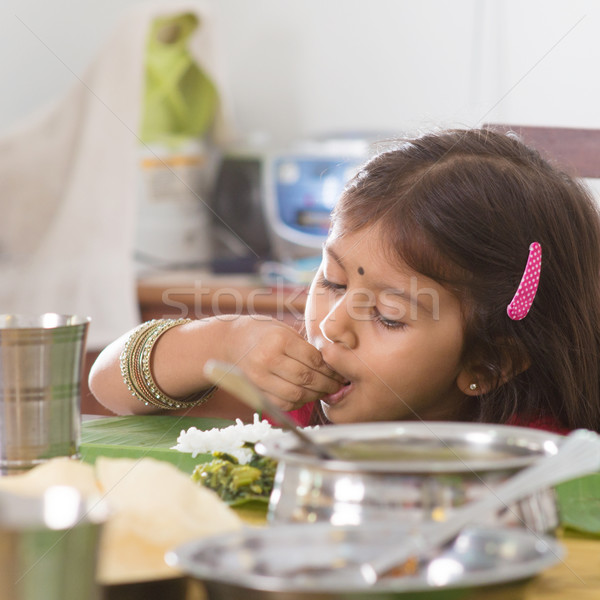 Indian girl eating rice Stock photo © szefei
