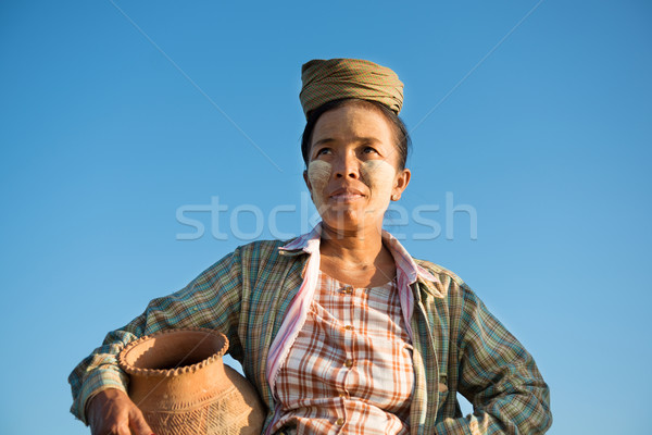 Mature Asian traditional female farmer carrying clay pot Stock photo © szefei