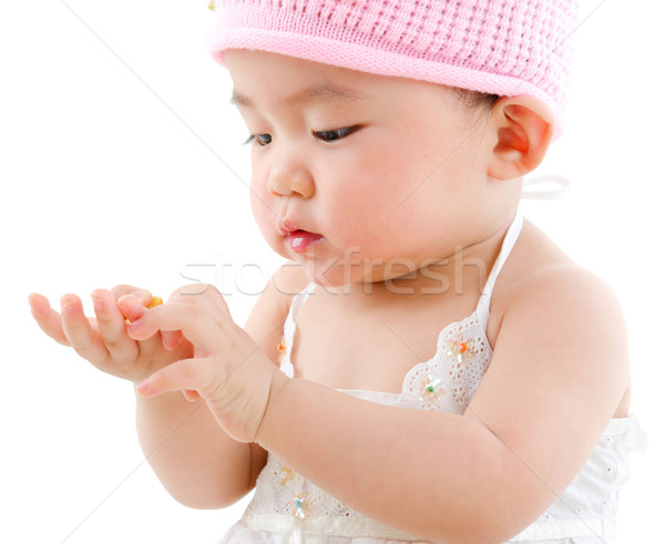 Asian baby girl eating snack Stock photo © szefei