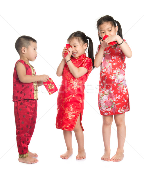 Asian children peeking into red packet  Stock photo © szefei