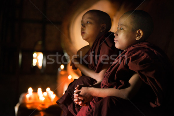 Buddhist novices praying inside temple Stock photo © szefei