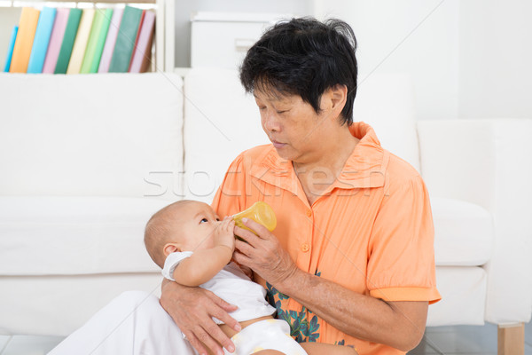 Nanny bottle feeding baby Stock photo © szefei