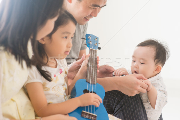 Family playing ukulele at home Stock photo © szefei