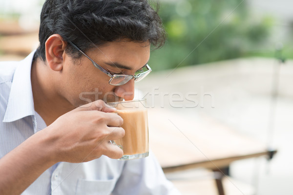 Indian businessman sipping a cup hot milk tea  Stock photo © szefei