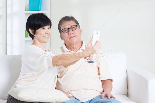 Senior using smart phone making selfie Stock photo © szefei