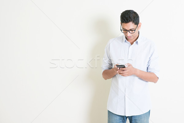 Casual business Indian male using smartphone Stock photo © szefei