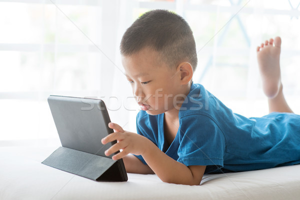Stock photo: Child addicted to tablet.