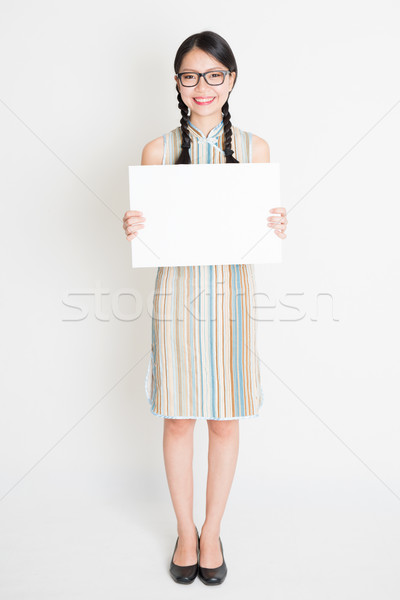 Oriental girl holding white paper card Stock photo © szefei