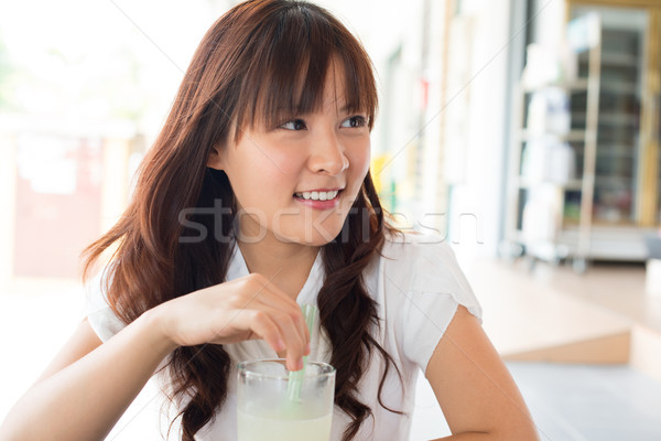Stock photo: Young Asian woman enjoying drinks