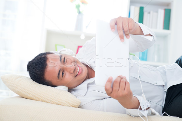 Asian homme écouter chanson canapé casque [[stock_photo]] © szefei