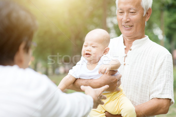 [[stock_photo]]: Grands-parents · petit-enfant · extérieur · bébé