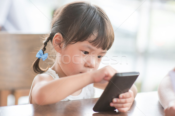 Girl using smart phone Stock photo © szefei