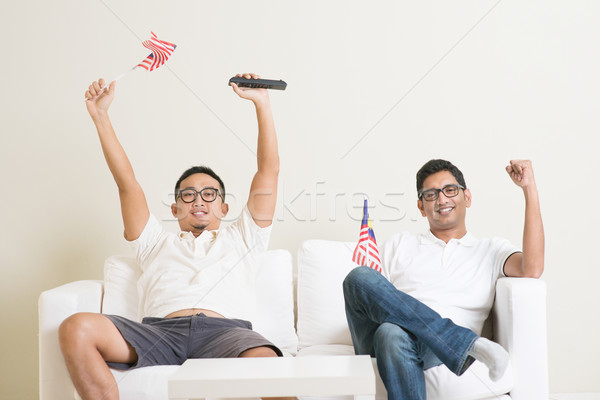Malaysian men watching sports on tv Stock photo © szefei