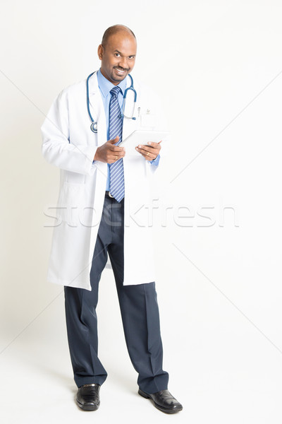 Mature Indian doctor full length using tablet computer Stock photo © szefei