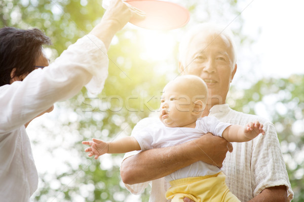 Grandparents playing with grandson at park. Stock photo © szefei