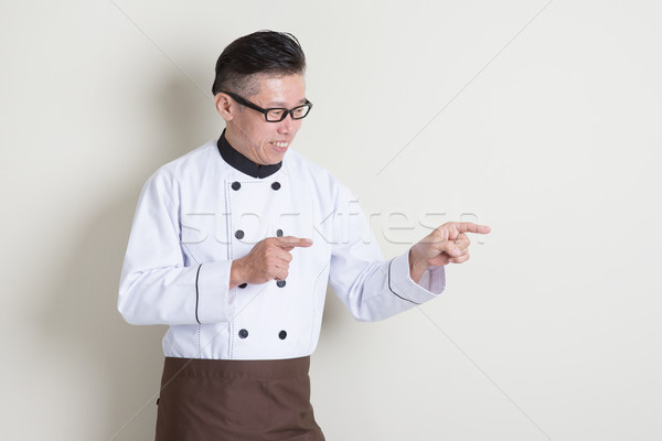 Mature Asian Chinese chef pointing Stock photo © szefei