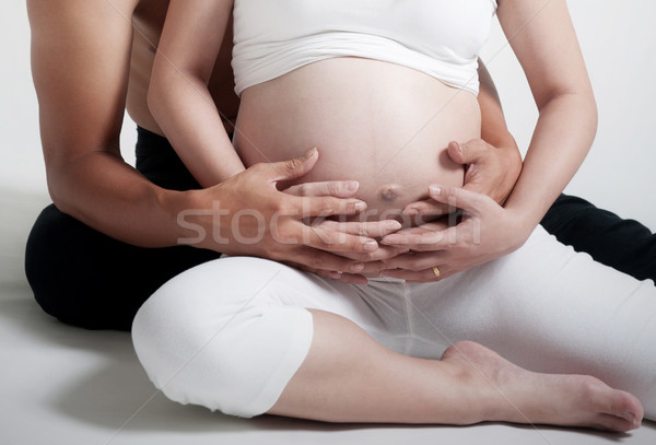 Moederschap zwangere vrouw echtgenoot vergadering vloer holding handen Stockfoto © szefei
