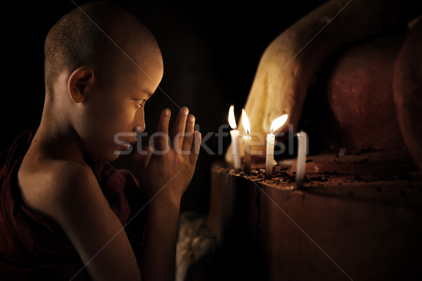 Pregando piccolo monaco fronte lume di candela Foto d'archivio © szefei