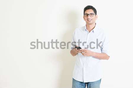 Stock photo: Casual business Indian male using mobile apps