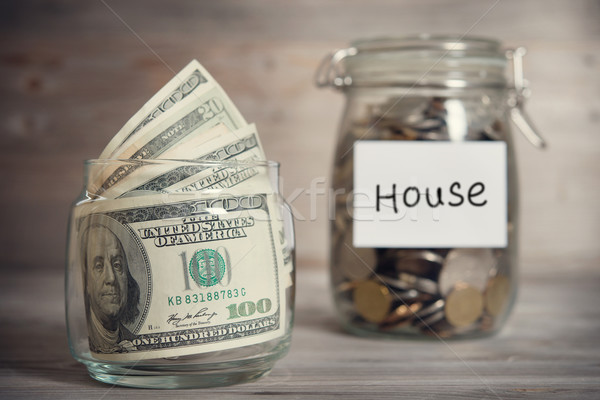 Stock photo: Dollars and coins in jar with house label