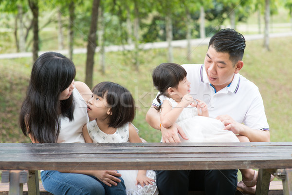 Asian family bonding outdoors with empty table space.  Stock photo © szefei