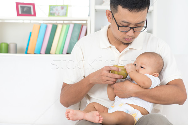 Stock photo: Father bottle feeding baby
