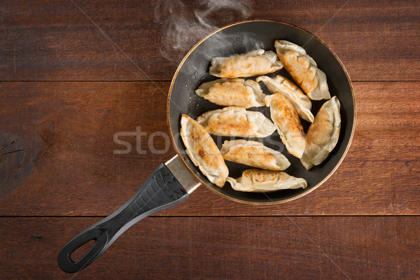 Asian food fried dumpling in cooking pan Stock photo © szefei