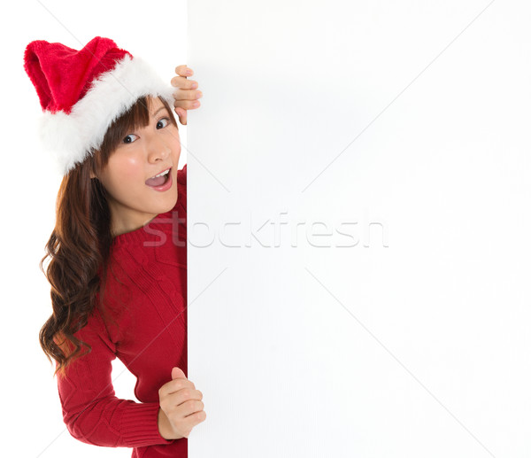 Santa girl peeking from behind blank sign billboard.  Stock photo © szefei