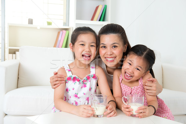 Stock photo: Mother and daughters drinking milk 