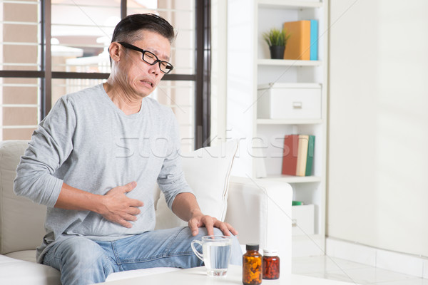 Mature Asian man stomachache Stock photo © szefei